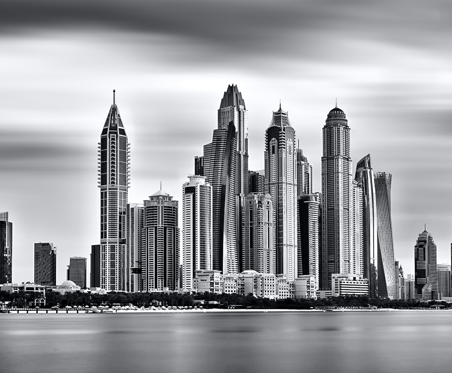 Waterfront towers rising above a marina at dusk